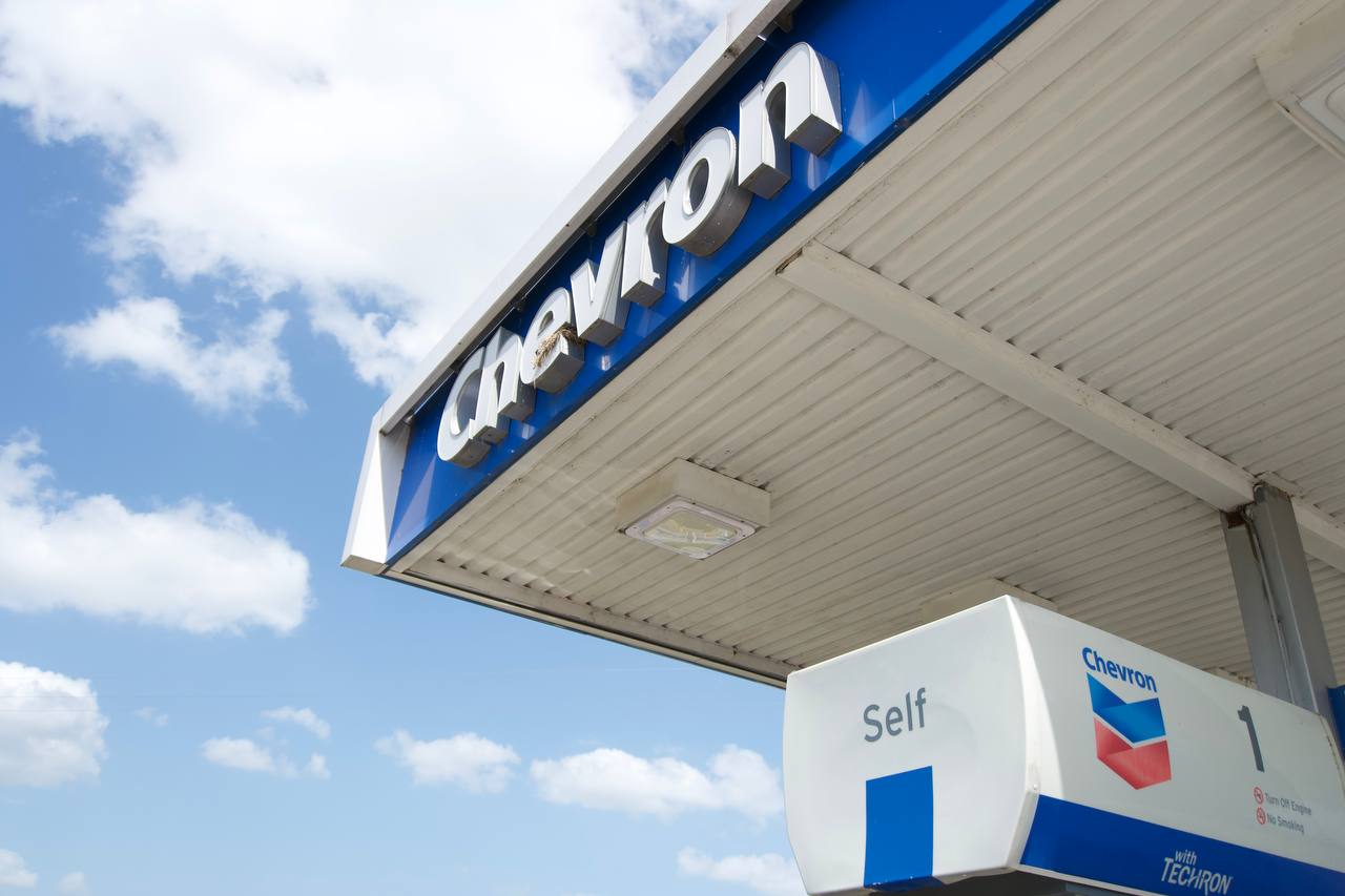 Low-angle tilted photograph of a Chevron gas station canopy against a blue sky